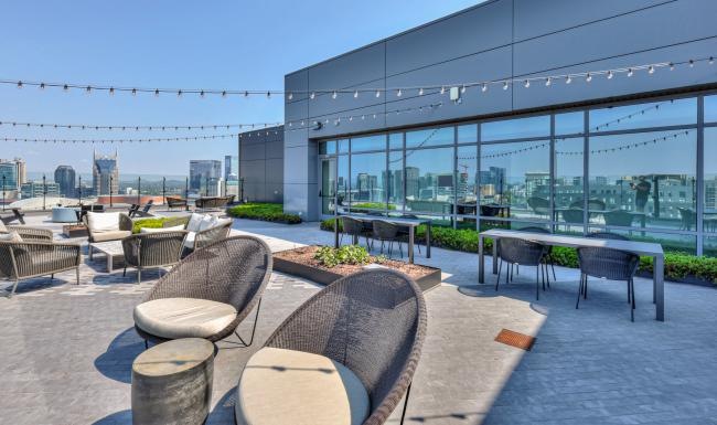a patio with chairs and tables and a view of a city